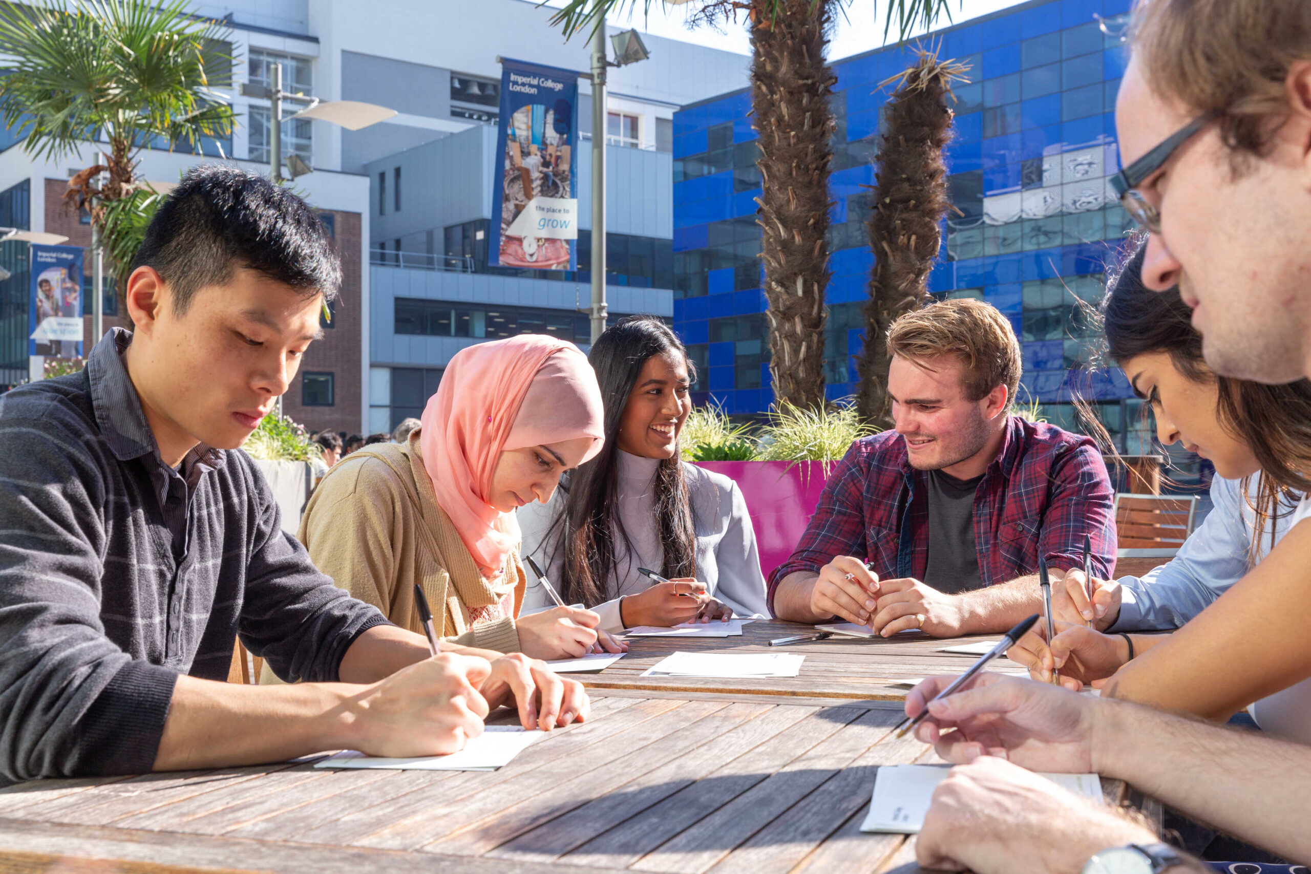 A group of students studying outside at a table.