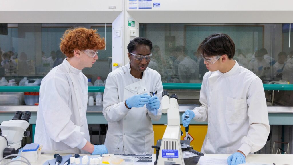 Three students in lab coats